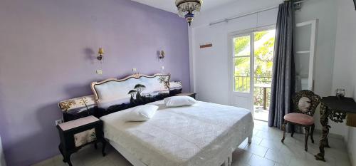 a bedroom with a bed and a chair and a window at Kapetanios Luxury in Agios Georgios