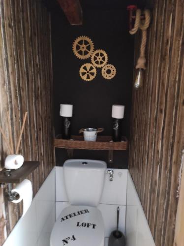 a bathroom with a toilet and some gears on the wall at Navajos in Buis-les-Baronnies