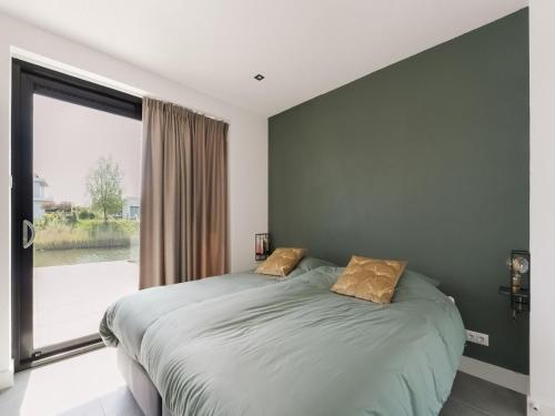 ゼーウォルデにあるSwanky villa in Zeewolde with gardenの大きなベッドと大きな窓のある寝室