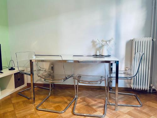 a glass table and two chairs in a room at 70m2 apartment 4 mins from Athens central station! in Athens