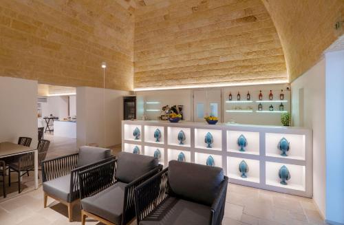 a living room with chairs and a kitchen at Dimora San Giuseppe Hotel & SPA in Otranto