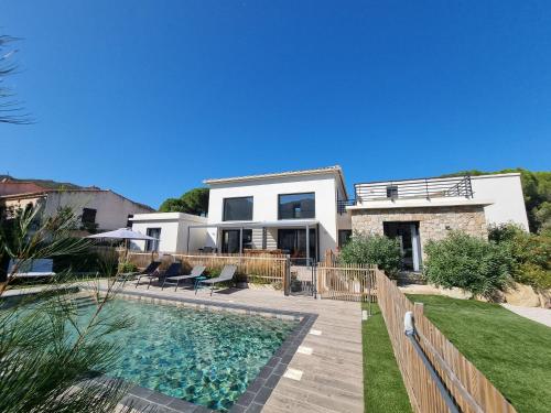 une maison avec une piscine devant dans l'établissement Villa Célestine, à Calvi