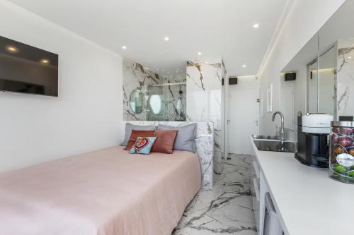 - une chambre avec un lit et un lavabo dans l'établissement Caraïbes Heliopolis naturiste, au Cap d'Agde