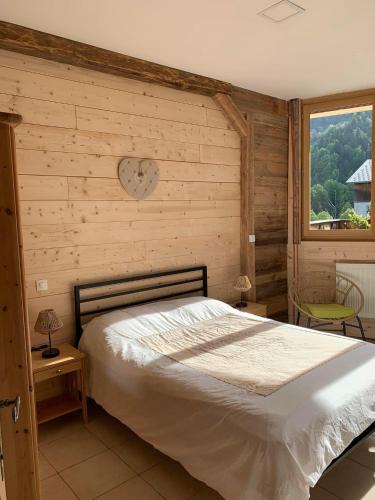 une chambre avec un lit et une horloge au mur dans l'établissement Terrasse sur les Aravis, à La Giettaz