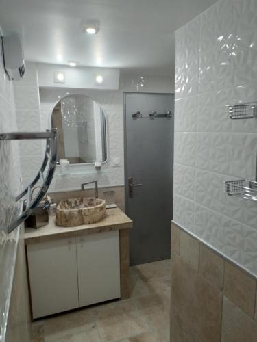 ein Bad mit einem Waschbecken, einem Spiegel und einer Dusche in der Unterkunft Gîte, suite d'hote de charme, petit déjeuner compris in Firmi