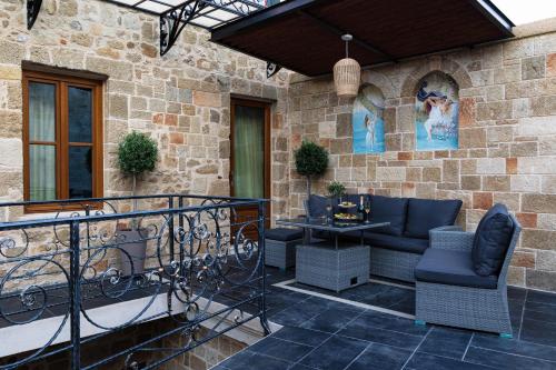 een patio met stoelen en een tafel aan een stenen muur bij Chateau Anax Boutique Hotel in Rhodos-stad