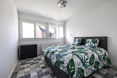 een slaapkamer met een bed met een groen en wit dekbed bij le zentop in Chalon-sur-Saône