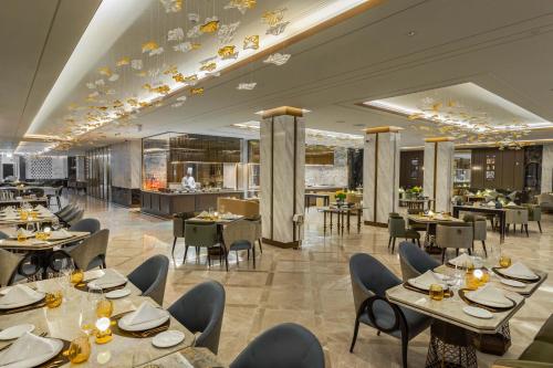 a restaurant with tables and chairs and a bar at Taj Exotica Resort & Spa, The Palm, Dubai in Dubai