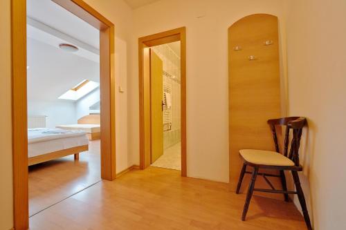 a hallway with a chair and a door to a bedroom at Penzión a Reštaurácia u Jeleňa in Stará Ľubovňa