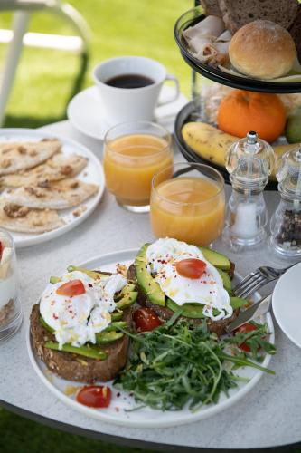 a table with a plate of food with eggs on it at Mossa Well Being Hotel - Heated pool in Kato Daratso