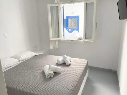 2 toallas en una cama en una habitación con ventana en Ground floor Apartment in Mykonos Town, en Mykonos ciudad