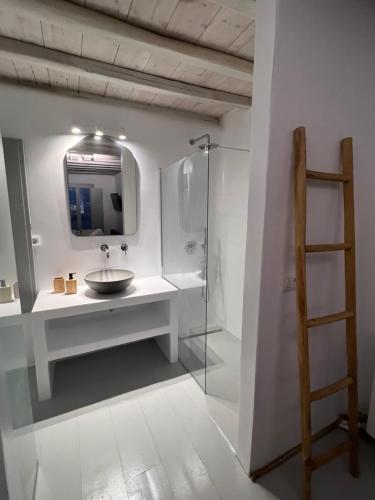 Villa Amarone في مدينة ميكونوس: حمام مزود بحوض ومِرآة