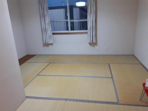 an empty room with a window and a wooden floor at 春日ハウス KasugaHouse in Tsukuba