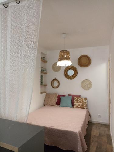 - une petite chambre avec un lit et une lampe pendant dans l'établissement Hébergement sur l île de Martigues, la Venise provençale, à Martigues