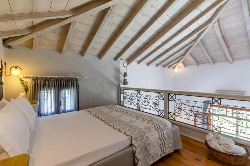 a bedroom with a white bed and a balcony at Irida Apartments in Stafylos