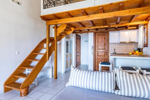 a staircase in a living room with a kitchen at Irida Apartments in Stafylos