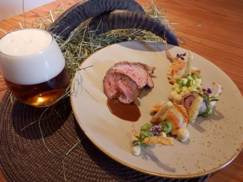 un plato de comida junto a un vaso de cerveza en Braugasthof Glocknerblick, en Kals am Großglockner