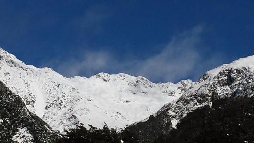 a snow covered mountain with a blue sky at The Tussocks, Arthur's Pass in Arthur's Pass