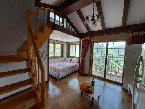 a bedroom with a bed and a staircase in a room at Beljari Pension in Tongyeong