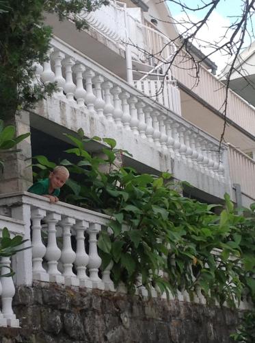 a man looking out of a window on a building at Seaview Apartments in Krasici