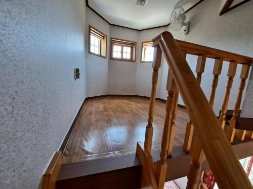 an empty room with a staircase in a house at Beljari Pension in Tongyeong