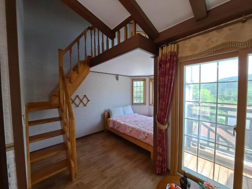 a bedroom with a bunk bed and a staircase at Beljari Pension in Tongyeong