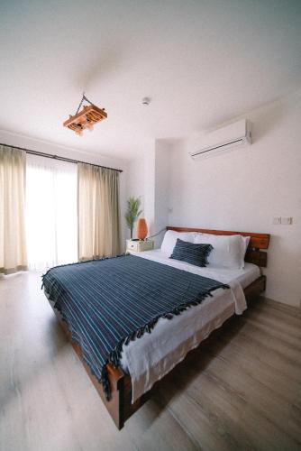 a bedroom with a large bed and a large window at Pupa Alaçatı Butik Otel in Cesme