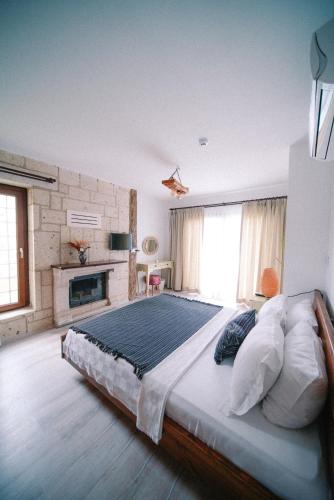a large bedroom with a large bed and a fireplace at Pupa Alaçatı Butik Otel in Cesme