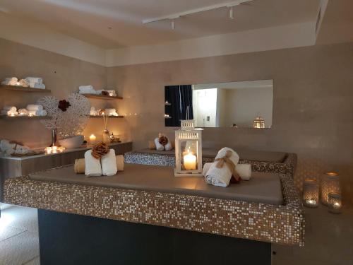 een kamer met een aanrecht met kaarsen en een spiegel bij Hotel Nettuno in Lido di Jesolo