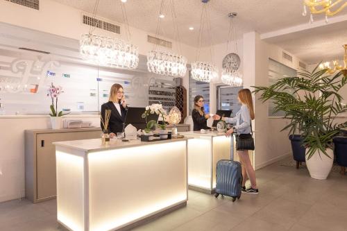 three women standing at a counter in a store at Hotel Nettuno in Lido di Jesolo