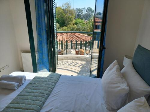 een slaapkamer met een bed en een groot glazen raam bij PALMAR CLUB - Villa EMMANUELA in Marathón