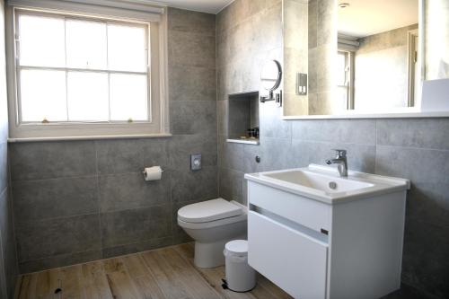 a bathroom with a white sink and a toilet at Dover Marina Hotel & Spa, Tapestry Collection by Hilton in Dover