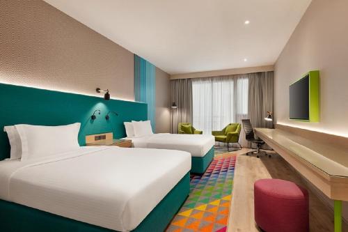 a hotel room with a bed and a desk at La Quinta by Wyndham Dubai Jumeirah in Dubai
