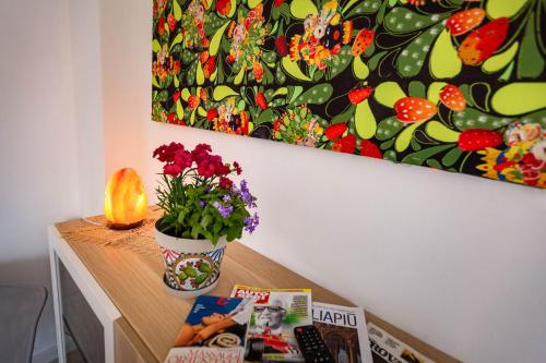 a table with a plant and a painting on the wall at Bianca Casa in Bolognetta