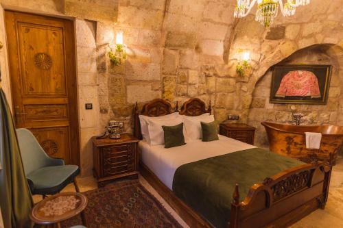 a bedroom with a bed and a chair in a room at Solo Cave Suites in Nevsehir