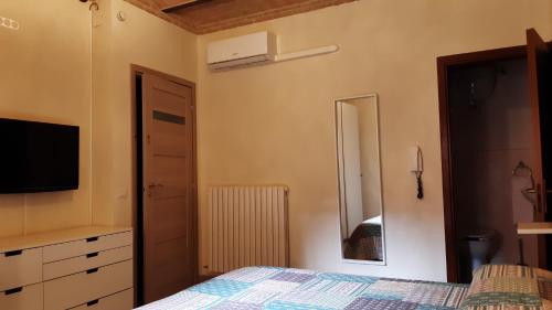 a bedroom with a bed and a flat screen tv at Casa Vacanze Amira, al Centro dell' Umbria ! in Petrignano