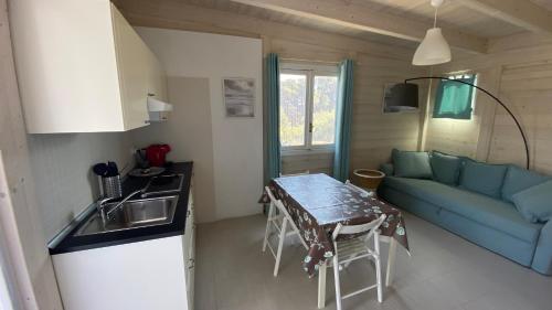 a kitchen and living room with a table and a couch at Cottage Mare e Stelle in San Domino