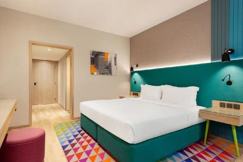 a bedroom with a large bed with a blue headboard at La Quinta by Wyndham Dubai Jumeirah in Dubai