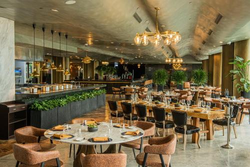 a restaurant with tables and chairs and a bar at YOHO Hollywood Roosevelt Hotel in Macau