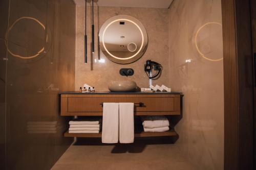 Panagia Premier Trabzon في طرابزون: حمام مع حوض ومرآة ومناشف