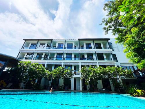 a building with a swimming pool in front of it at Z&Z Resort in Rawai Beach