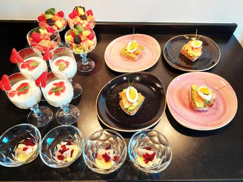 a table with plates of desserts and wine glasses at Cha Cha de Loup Luxe B&B - Vakantiewoning in Rendeux