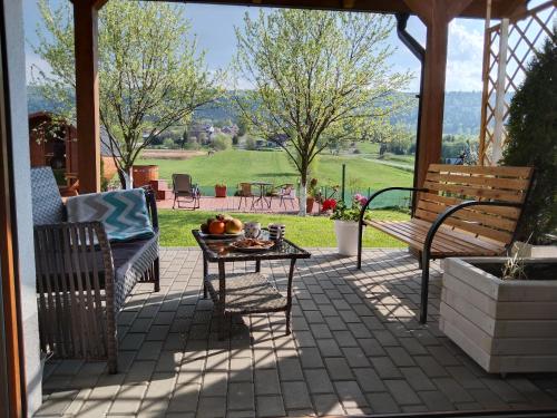 a patio with a table and benches and a view at Apartamenty Równia 2 in Ustrzyki Dolne