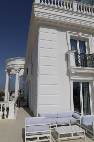 a white building with two chairs and a balcony at Hotel Villa Pascucci in Durrës