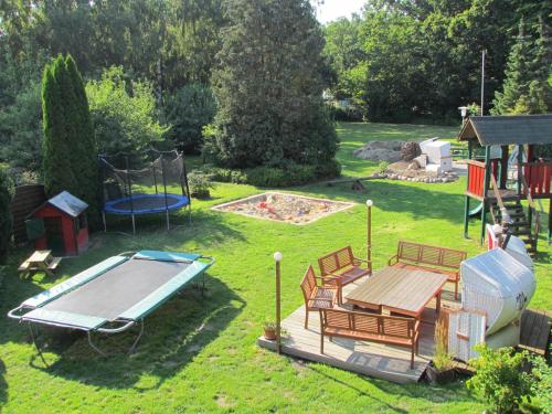 a backyard with a pool and a picnic table and a playground at Haus Tanneck, Nr 9 in Kellenhusen
