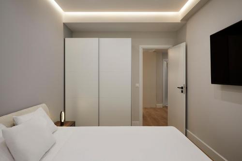 a bedroom with a white bed and a closet at Central & Comfy apartment 2mins walking from metro in Athens