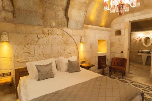 a bedroom with a large bed with a stone wall at Solo Cave Suites in Nevsehir