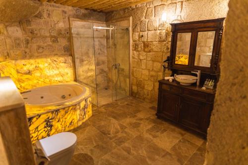 a bathroom with a tub and a shower and a sink at Solo Cave Suites in Nevsehir