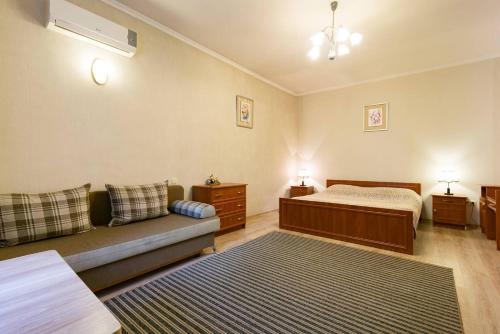 ein Wohnzimmer mit einem Bett und einem Sofa in der Unterkunft Nadezhda Apartment on Nauryzbay Batyra 37/1 in Almaty