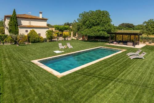 a large yard with a swimming pool and a house at Can Cristus in Monells